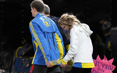 People leave the scene after explosions went off at the 117th Boston Marathon in Boston